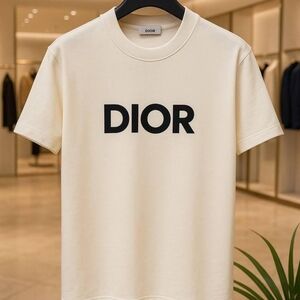 a beige DIOR T-shirt with a bold black logo on the front, hanging